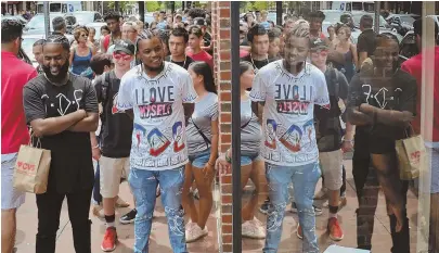  ?? STAFF PHOTOS BY CHRIS CHRISTO ?? ‘DAMN’ POPULAR: Fans, above, line up yesterday along John F. Kennedy Street in Cambridge to get into Kendrick Lamar’s pop-up shop, top right. Zachary Patterson, top left, shows off his new shirt.