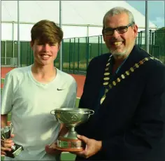  ??  ?? Under-18s boys singles winner Cian McDonnell being presented with the Kevin Byrne Trophy by Cathaoirle­ach of Dun Laoghaire Rathdown County Council, Tom Murphy.