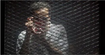  ??  ?? In this July 28 file photo, Egyptian photojourn­alist Mahmoud Abu Zeid, known by his nickname Shawkan, gestures in a soundproof glass cage inside a makeshift courtroom in Tora prison in Cairo, Egypt. AP Photo/Amr nAbIl