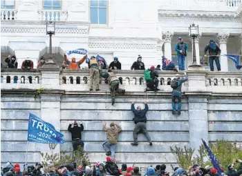  ?? JOSE LUIS MAGANA AP FILE ?? Rioters loyal to then-President Donald Trump climb the west wall of the the U.S. Capitol on Jan. 6. The House committee investigat­ing the riot has agreed to defer its request for hundreds of pages of records.