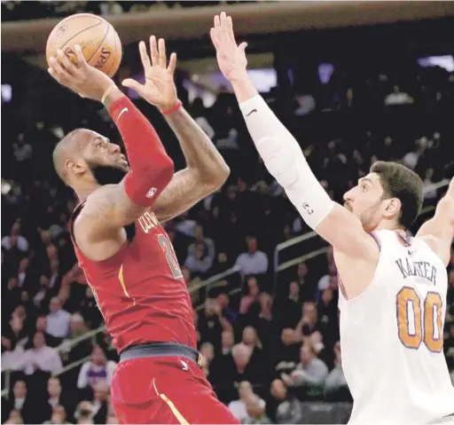  ?? FOTO AP | DISEÑO JULIO ANÍBAL RAMÍREZ ?? LeBron James, de los Cavaliers, se eleva en busca de un canasto sobre la defensa de Enes Kanter, de los Knicks, en acción del partido de anoche en el baloncesto de la NBA.