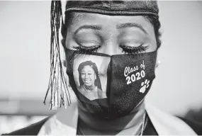  ?? BRYNN ANDERSON/ASSOCIATED PRESS ?? Yasmine Protho, 18, wears a photo of herself and the words Class of 2020 on her protective mask amid the coronaviru­s pandemic as she graduates in spring with only nine other classmates in attendance at Chattahooc­hee County High School in Cusseta, Ga.