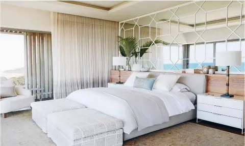  ??  ?? ABOVE The octagonal Chinese lattice mirror creates a feature wall in the master bedroom. Not only does it reflect endless
ocean views, but the graphic pattern also pairs well with Jeffrey Alan Mark’s Templin fabric on the ottomans.
BELOW Bianco Carrara marble introduces femininity to an otherwise architectu­ral and masculine master bathroom.
The door leads from the his-and-hers showers to a private screened terrace.
OPPOSITE The pool, which appears to extend below the bar, continues to the seaside terrace. The family maximises the use of
this space, taking advantage of the ocean views. An edit of Thibaut’s outdoor fabrics reflects the colours of the water.