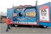  ?? [AP PHOTO] ?? Amazon worker Khayyam Kain begins to open an Amazon Treasure Truck at a parking lot in Seattle. The Treasure Truck is a quirky way for the online retailer to connect with shoppers in person, expand its physical presence and promote itself. Amazon has...