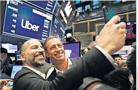  ??  ?? Dara Khosrowsha­hi, the Uber chief, left, and Ryan Graves, a board member, pose for a photo before its New York listing. The float got off to a rocky start when shares dipped below the $45 offering price