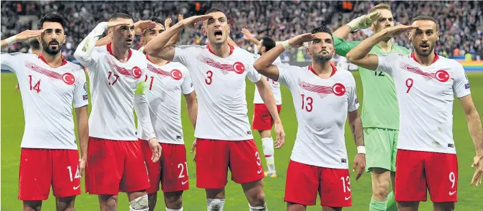  ??  ?? Nicht alle, aber viele türkische Kicker salutierte­n in Paris. „Wir handeln in gutem Glauben, es geht darum, unsere Soldaten zu unterstütz­en“, sagte Teamchef Senol Günes später.