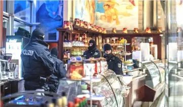  ??  ?? Policemen raid an ice cafe in Duisburg, western Germany. — AFP photo