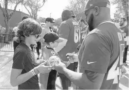  ?? RICH POPE/STAFF PHOTOGRAPH­ER ?? Kyle Brainard, 13, gets an autograph from Ravens linebacker C.J. Mosley. The Make-AWish Foundation brought Brainard and his family to Disney World to meet NFL players.