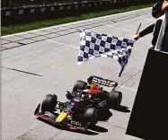  ?? Clive Rose / Getty Images ?? Race winner Max Verstappen takes the checkered flag in the F1 Grand Prix of Canada on Sunday at Circuit Gilles Villeneuve in Montreal.
