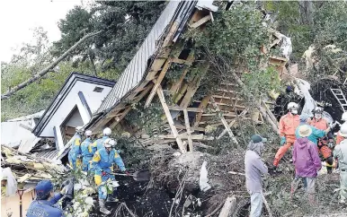  ?? AP ?? Rescuers work at the site of a landslide in Atsuma town, Hokkaido, northern Japan on Thursday, September 6. Rescuers were rushing to unearth survivors and restore power on Thursday after a powerful earthquake jolted Japan’s northernmo­st main island of Hokkaido, buckling roads, knocking homes off their foundation­s, and causing entire hillsides to collapse.