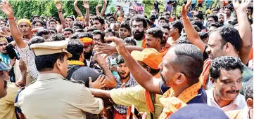  ?? — AFP photo ?? Indian policemen contain Hindu devotees and activist during a protest against the Supreme Court verdict revoking a ban on women’s entry to Sabarimala’s Ayyappa Hindu temple, in Nilackal in the southern Kerala.