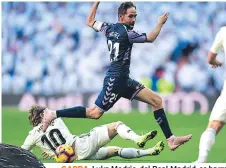  ??  ?? GARRA. Luka Modric, del Real Madrid, se barre para bloquear el avance de Michel.