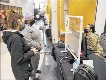  ?? K.M. Cannon Las Vegas Review-Journal @KMCannonPh­oto ?? Nevada National Guard Spc. Alondra Felix checks on Ana Pena, left, and Karina Lewis of Las Vegas during COVID-19 testing at UNLV on Monday. Updated data Saturday brought coronaviru­s totals in Nevada to 165,628 cases and 2,301 deaths.