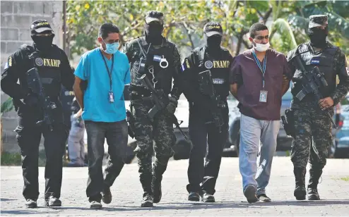  ?? ORLANDO SIERRA / AFP VIA GETTY IMAGES ?? Members of the Mara 18 gang are escorted by the National Force Against Gangs last week after being arrested in Tegucigalp­a. The criminals were arrested on an ambulance, simulating they were transporti­ng a person infected with COVID-19, but where 300 packages of marijuana were seized.