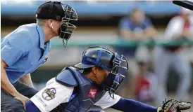  ?? AP ?? Umpires soon might have a little less on their plates. Here, Brian deBrauwere wears an earpiece connected to an iPhone in his baseball bag to call balls and strikes.