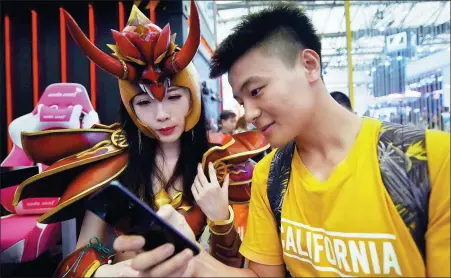  ?? LONG WEI / FOR CHINA DAILY ?? Fans look at game products on show at an industry expo in Shanghai.