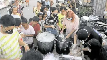  ?? — ALIBYO CEBU-AYUDA NETWORK PHOTOS ?? Volunteers serving warm “lugaw” to resident evacuees at Cebu Internatio­nal Convention Center in Mandaue City, Cebu.