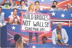  ??  ?? A protester holds up a sign as Trump speaks during the Republican National Convention. —AFP photo