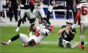  ?? AP Photo/Isac Brekken ?? Tampa Bay Buccaneers inside linebacker Devin White (45) sacks Las Vegas Raiders quarterbac­k Derek Carr (4) during the first half of an NFL football game, on Sunday in Las Vegas.