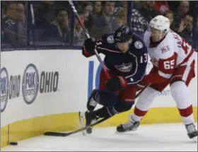  ?? JAY LAPRETE — ASSOCIATED PRESS ?? The Red Wings’ Danny DeKeyser, right, trips the Blue Jackets’ Cam Atkinson during the second period April 3 in Columbus. DeKeyser was penalized on the play.