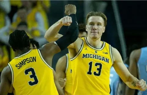  ?? Leon Halip/Getty Images ?? Ignas Brazdeikis, right, and Zavier Simpson celebrate a 3-point play in the Wolverines’ 84-67 defeat of North Carolina Wednesday. After reaching last season’s championsh­ip game, Michigan has steamrolle­d through the first month of its schedule.