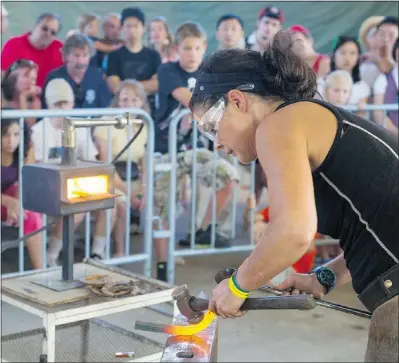  ?? GERRY KAHRMANN/PNG ?? Blacksmith Michelle Hague makes horseshoes at the PNE on Wednesday.