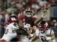  ?? ASSOCIATED PRESS FILE ?? Alabama quarterbac­k Tua Tagovailoa passes as he is hit by Louisville defensive lineman Jared Goldwire, left, and defensive end Derek Dorsey during the first half, in Orlando, Fla.