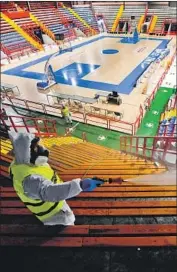  ?? Ciro Fusco EPA/Shuttersto­ck ?? WORKERS sanitize a facility in Naples, Italy. The country is so hard-hit by the coronaviru­s that fans have been banned from attending sporting events.