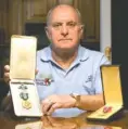  ?? STAFF PHOTO BY C.B. SCHMELTER ?? Harland J. Sutherland Jr. poses with his Army Commendati­on Medal with “V” device, left, and Bronze Star Medal.