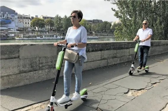  ?? Photos by Carolyn Said / The Chronicle ?? People ride Lime scooters alongside the Seine near the Louvre. The scooters are popular in Paris, which has a long history with two-wheel forms of transport.