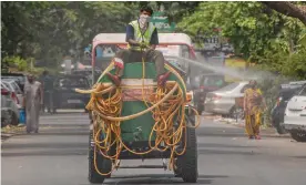  ?? — PTI ?? A worker sanitizes a street in Noida on Thursday.