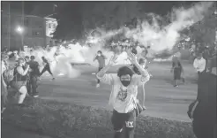  ?? Zuma Press/tns ?? Tear gas lands around protesters after they refused to listen to police demands to disperse near the courthouse in Kenosha, Wisconsin on Tuesday.