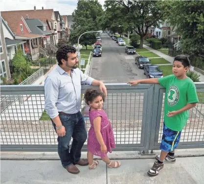  ?? PHOTOS BY TYLER MALLORY, USA TODAY ?? Juan Carlos Linares, shown with his children, Amaru and Maya, is executive director of LUCHA, a Chicago group that backs an ordinance that would make it costly for developers to tear down homes near The 606 trail.