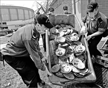  ?? STEVE HELBER/ AP ?? Canadian sailors carry out broken dishes from the Mississipp­i Coast Coliseum and Convention Centre, damaged by Hurricane Katrina, as they help this week with the cleanup in Biloxi, Miss. “It was amazing what the Canadians got done,” one local official said.