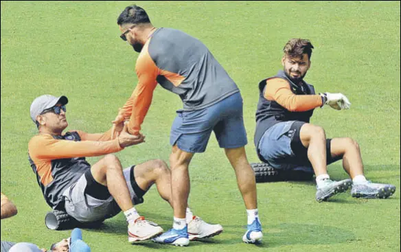  ?? PTI ?? Rishabh Pant looks on as Virat Kohli gives MS Dhoni a helping hand during a practice session at the ACA Stadium in Guwahati on Saturday.