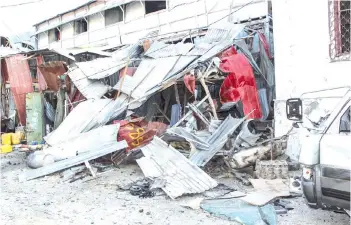  ?? — AFP photo ?? Debris remain at the blast site from a suicide car bombing attack from the day before at the side of Afrik Hotel in Mogadishu, Somalia.