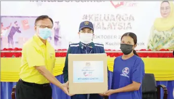  ?? ?? Halimah (centre) presents a food box to a recipient with the assistance of Lo.