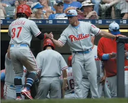  ?? AARON GASH — THE ASSOCIATED PRESS ?? The Phillies’ Odubel Herrera (37) is congratula­ted by manager Gabe Kapler after scoring a run against the Brewers, Sunday in Milwaukee. Kapler’s style has been questioned by many, but his even keel approach has the clubhouse in order and the team cruising right along.