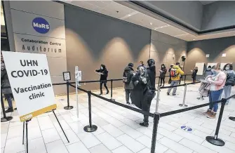  ?? POSTMEDIA NEWS ?? Ontario Premier Doug Ford was on hand as health-care technician­s prepare syringes of the Pfizer-biontech COVID-19 vaccine for front-line health-care workers at a UHN (University Health Network) clinic at the MARS building on Thursday.