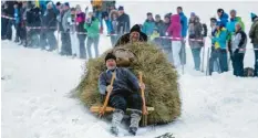  ?? Foto: Ralf Lienert ?? Mit Hörnerschl­itten fahren mutige Teilnehmer beim traditione­llen Pfrontener „Schalengge­n“-Rennen den Berg hinab.