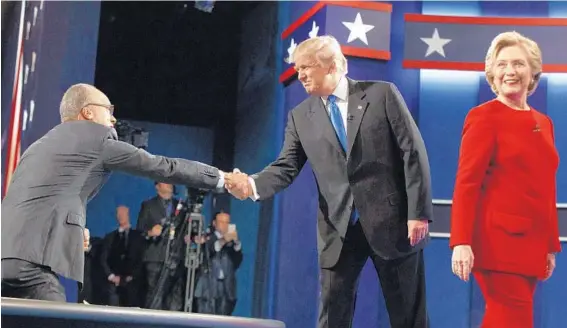  ?? EVAN VUCCI/ASSOCIATED PRESS ?? Republican presidenti­al candidate Donald Trump, center, shakes hands with moderator Lester Holt as Democratic presidenti­al candidate Hillary Clinton walks to her lectern.