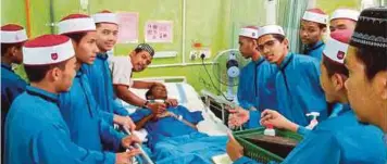  ??  ?? PELAJAR Maahad Tahfiz Al-Hashimi menziarahi Muhammad Faiz di Hospital Universiti Sains Malaysia.