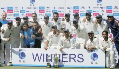  ??  ?? HYDERABAD: Members of Indian team pose with the winning trophy after their win over Bangladesh in their one-off cricket test match in Hyderabad, India, yesterday. India won the match by 208 runs. —AP