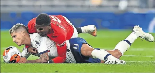  ??  ?? Lamela y Pogba se chocan y caen sobre el césped durante el empate entre Tottenham y Manchester United ayer en Londres.