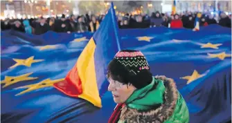  ?? VADIM GHIRDA, THE ASSOCIATED PRESS ?? People hold a large European Union flag during a December protest joined by hundreds in Bucharest, Romania. Asylum claims from Romanians have risen substantia­lly since the federal government stopped requiring Romanians to get a visa before entering...