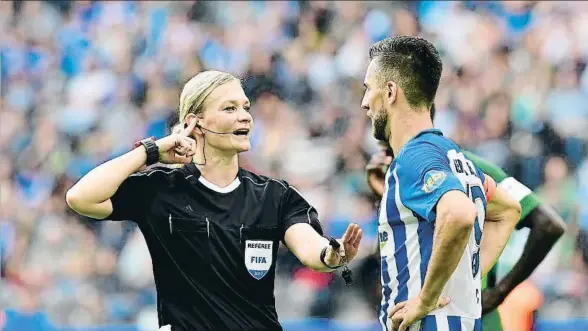  ?? TOBIAS SCHWARZ / AFP ?? Bibiana Steinhaus conversa con Vedad Ibisevic, delantero del Hertha Berlín, ayer