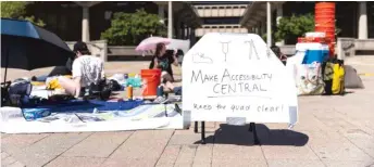  ?? ANTHONY VAZQUEZ/SUN-TIMES ?? A small group of students sit in UIC’s East Campus quad Monday, protesting plans to rip up the paving and replacing it with grass.