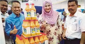  ??  ?? SURAYA (dua dari kanan) bersama Ahmad (dua dari kiri) bersama produk kordial jagung yang dilancarka­n pada Karnival Industri Asas Tani Zon Utara 2017.