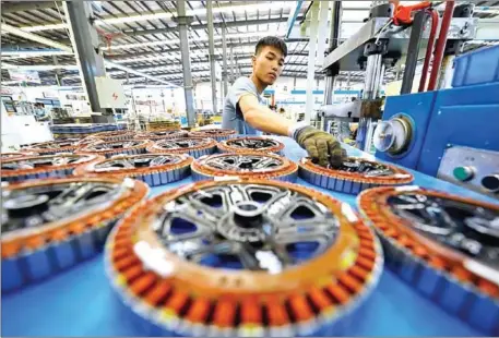  ?? SUPPLIED ?? An employee of an engine manufactur­er works on a production line in Tangshan, Hebei province, in September.