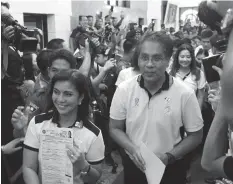  ?? PHILSTAR.COM/JONATHAN ASUNCION ?? Ruling Liberal Party presidenti­al candidate Mar Roxas (right) and his running mate Maria Leonor "Leni" Robredo show the crowd at the Commission on Elections main office their certificat­es of candidacy for the 2016 national elections.